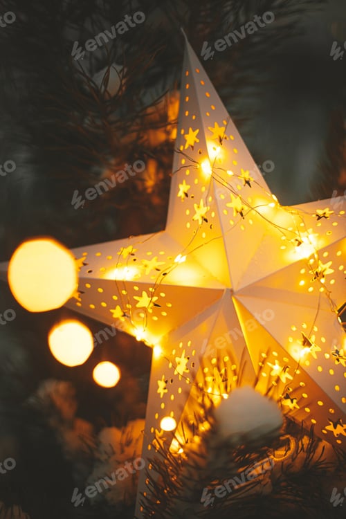 Preview: Merry Christmas! Christmas star glowing on snowy tree in night, close up. Atmospheric magic time