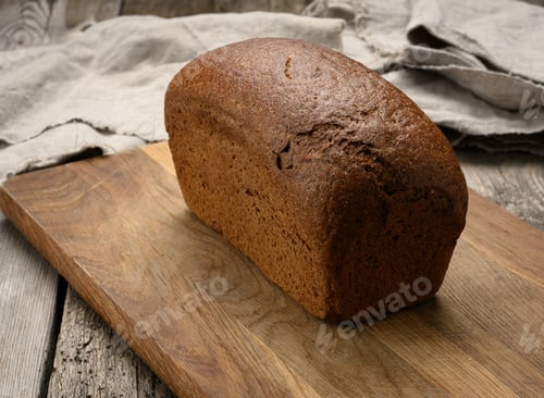 Preview: Baked rectangular rye flour bread on brown board