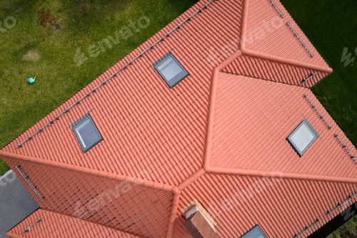 Preview: Closeup of attic windows on house roof top covered with ceramic shingles. Tiled covering of building