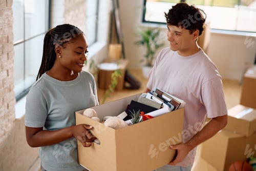 Preview: Young happy couple unpacking their belongings in a new home.