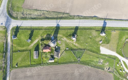 Preview: Aerial shot of a farm with old windmills , huts and cultivated lands