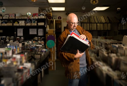 Preview: Mature man in record shop, sorting through records