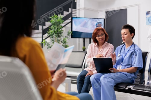 Preview: Health specialist consulting old patient in hospital lobby