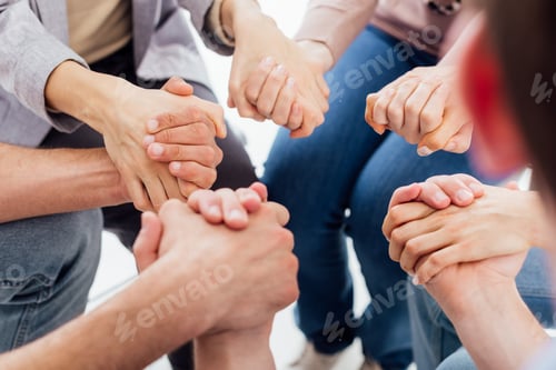 Preview: cropped view of people holding hands during group therapy session