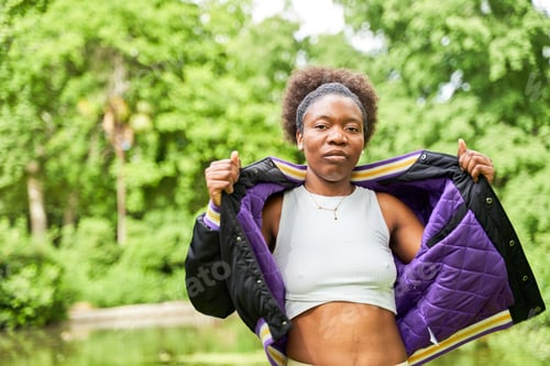 Preview: Portraits of a young African woman in a park, standing with a serene lake in the background