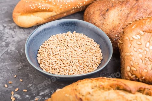 Preview: Different kinds of fresh baked bread on a black concrete background. side view, selective focus.