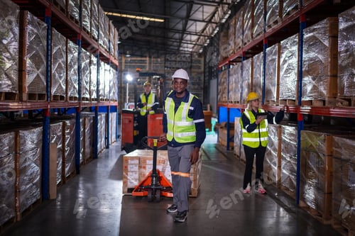 Preview: Warehouse workers under working factory cargo hand pulling pallet truck, stack cardboard boxes on wo