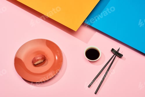 Preview: fresh nigiri with tuna near soy sauce and chopsticks on blue, pink, orange surface