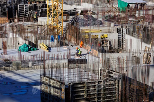 Preview: construction of a residential building or a shopping center. engineers and builders in helmets make