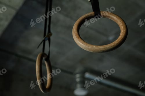 Preview: Artistic Gymnastics Still Rings Hanging in Gym against Concrete Ceiling