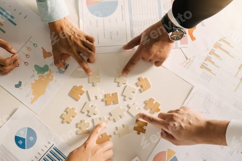 Preview: The concept of teamwork and partnership. Businessman's hands putting together puzzle