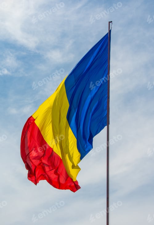 Preview: C\low angle shot of Romania flag on a cloudy sky background