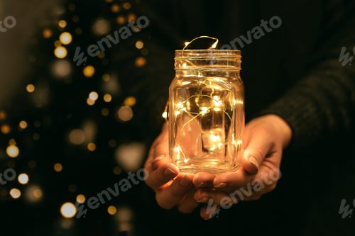 Preview: Woman holding holiday led light garland in jar. Christmas, new year holiday celebration concept.