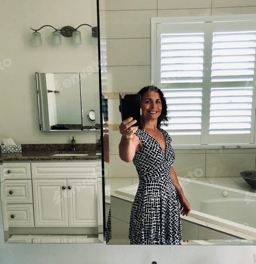 Visualização: Mulher confiante tirando uma selfie enquanto está no banheiro.