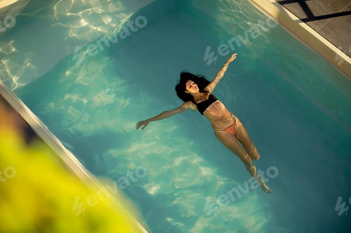 Preview: Aerial view of swimming woman floating in swimming pool
