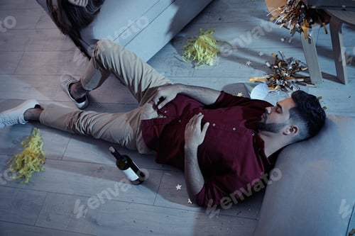 Preview: Young man sleeping in messy room after party, above view