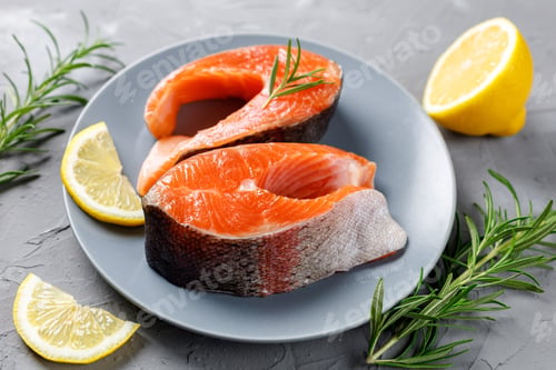 Preview: Steak of fresh raw red fish salmon with lemon, rosemary and pepper on grey background