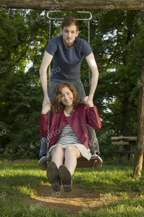 Preview: Cute Girl And Boy, On A Swing, Holding Hands.