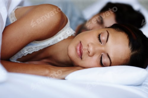 Preview: Dreaming away. Cute young couple sleeping in bed together.