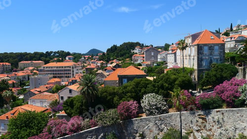 Preview: Beautiful view from the city wall to the houses outside the old town of Dubrovnik against a blue sky