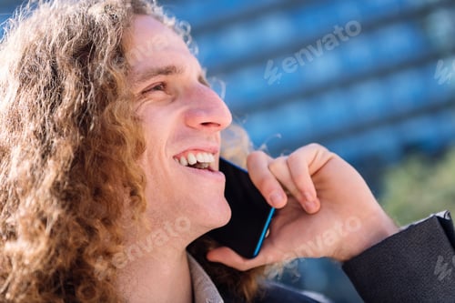 Preview: man laughing while talking by mobile phone