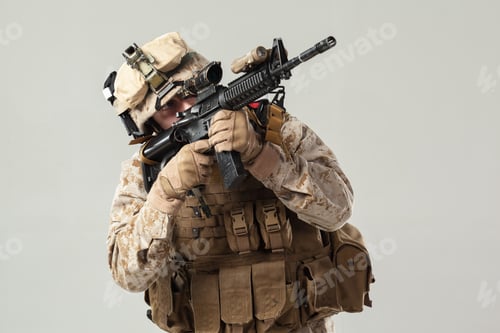 Preview: Soldier in camouflage holding rifle with focus on position and equipment in studio setting
