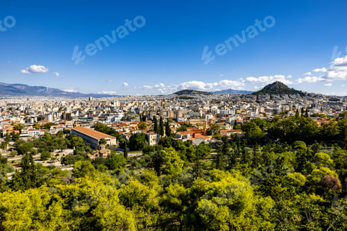 Preview: Cityscape of Athens surrounded by greenery under a blue sky and sunlight in Greece