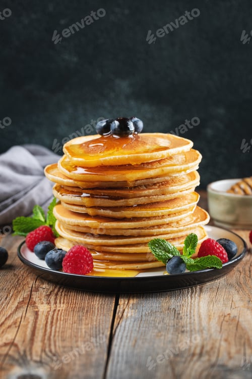 Preview: Delicious pancakes, with fresh blueberries, raspberry and maple syrup or honey on a dark background