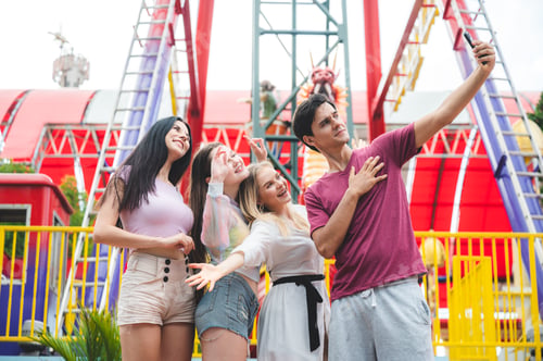 Preview: Group of happy best friends laughing and having fun at amusement park, holiday travel