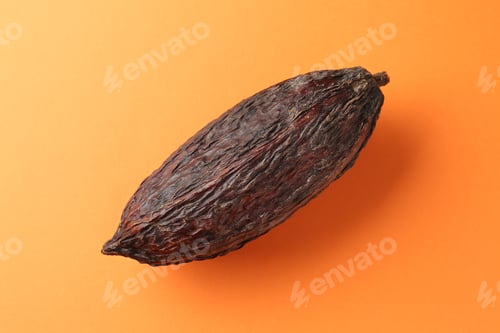 Preview: Natural cocoa pod on orange background, top view