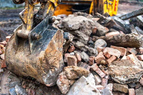 Preview: close-up of excavator bucket loading rocks, stones, earth and concrete bricks