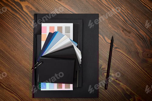Preview: flat lay with black notebooks, colors pallet and pencil on wooden tabletop