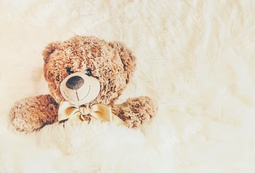 Preview: children's toy sleeps under the blanket. copy space. Selective focus.