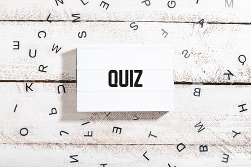 Preview: Quiz text on light box with chaos letters on white wood table desk