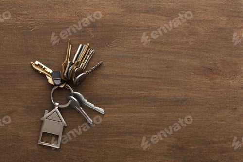 Preview: Bunch of keys with house shaped keychain on white wood