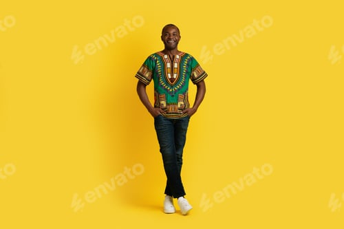 Preview: Positive attractive african man in traditional costume on yellow