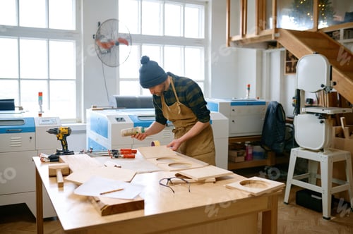 Preview: Portrait of experienced man carpentry worker applying glue on board