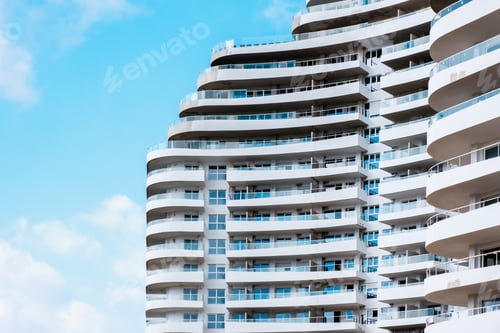 Preview: Detail of the large facade of a white building with terraces and balconies.