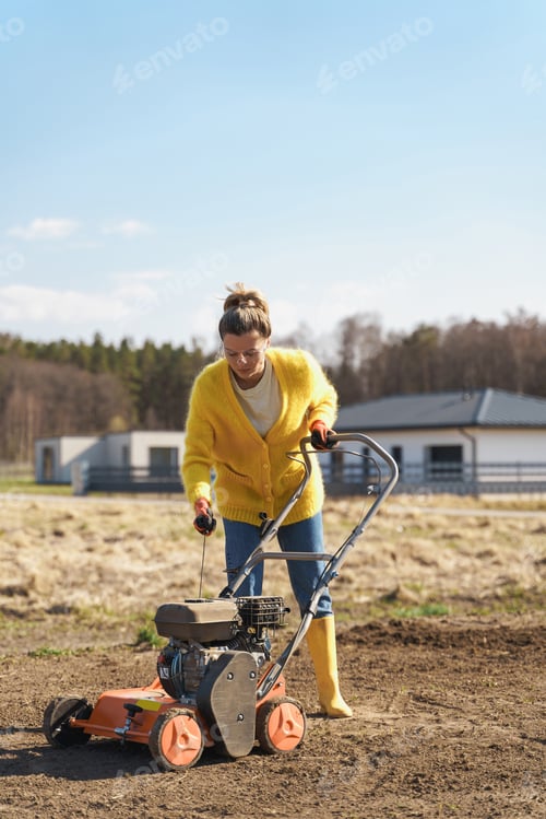 Preview: Woman villager is using aerator machine to scarification and aeration of lawn or meadow