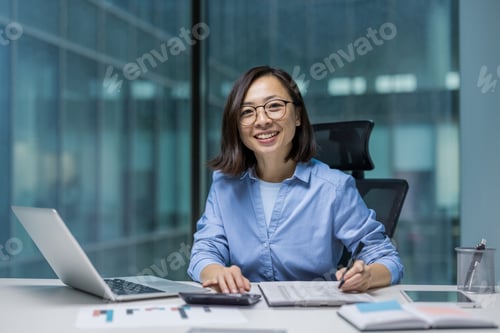 Preview: Portrait of young successful Asian accountant financier. Businesswoman behind paperwork smiling and