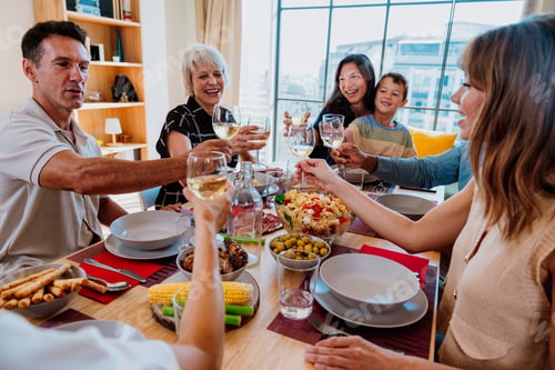 Preview: Family and friends reunion at home. Diverse family and friends celebrating together making a toast