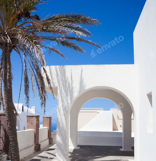 Preview: Traditional Greek architecture with white arch on blue sky.