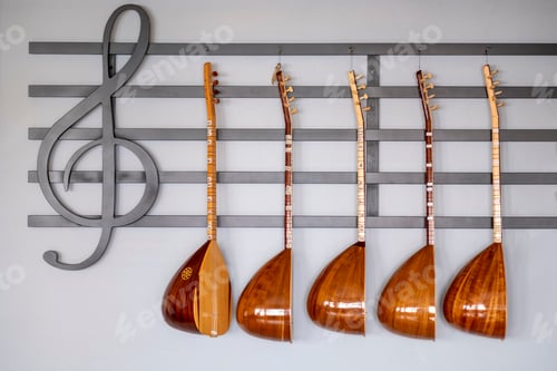 Preview: Closeup of several baglamas hanging on the treble clef.