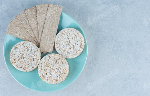 Preview: Tasty cracker and puffed rice cakes in the plate, on the marble background