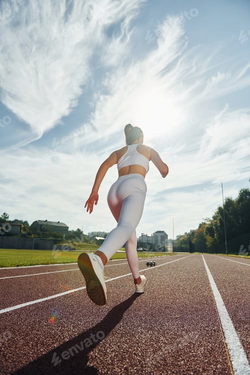 Preview: Active young woman in sportive clothes is exercising outdoors
