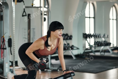 Preview: Sportive Woman Lifting Dumbbells In Gym