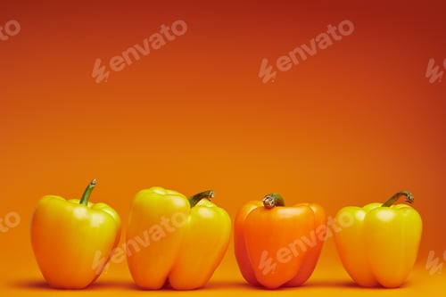 Preview: close-up view of fresh organic bell peppers on orange background