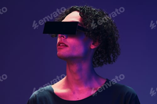 Preview: Interested stylish tanned curly man in black t-shirt trendy eyewear posing isolated on color pink