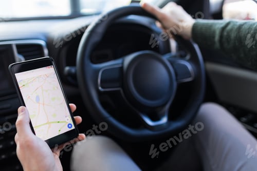 Preview: Cropped image of man using smartphone while driving car