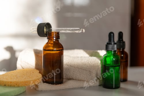 Preview: Amber glass dropper bottles with sponge in bathroom with shadows